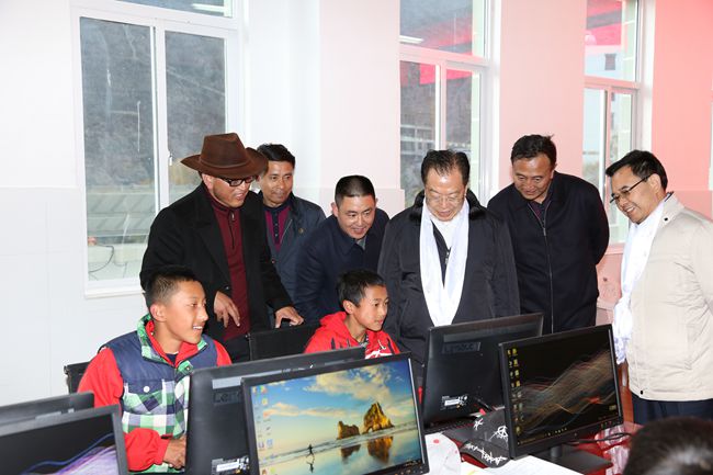 10、張學(xué)武董事長一行在集團(tuán)捐助的德欽縣“希望之星”電腦室考察，并饒有興致地教授學(xué)生使用搜索引擎_副本.jpg